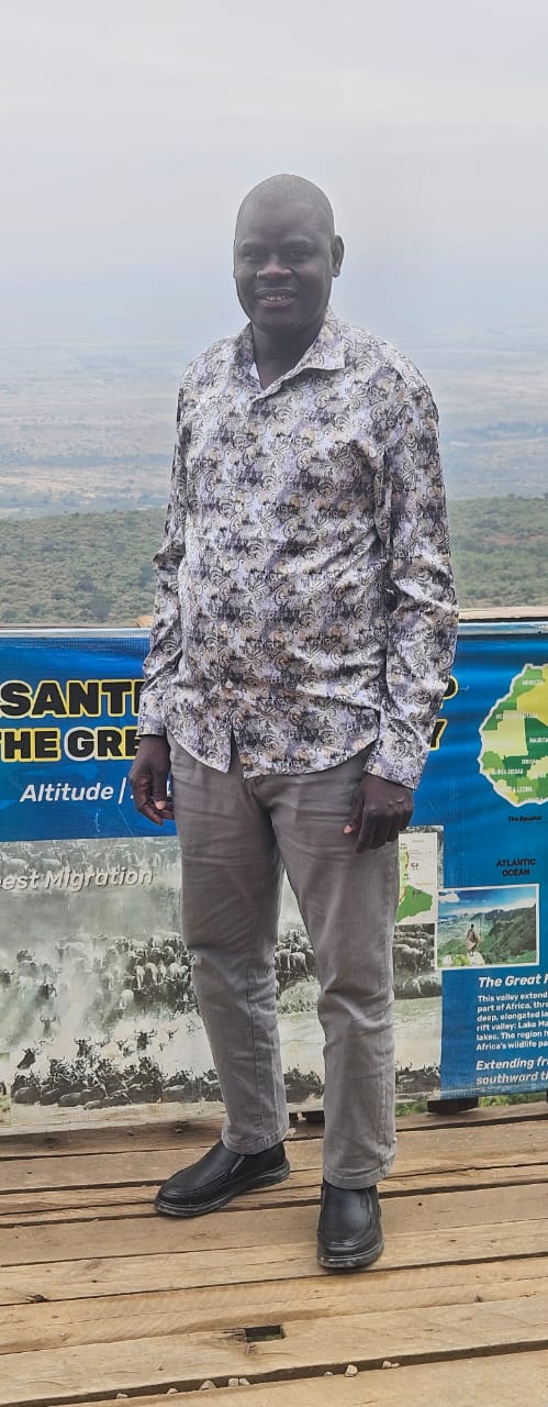 A member of the Thuri Community standing above an East African landscape
